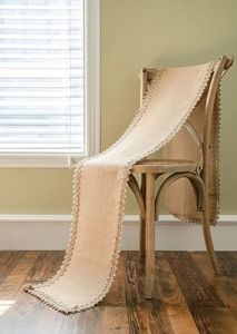 Close-up of natural jute table runner with delicate woven lace edges on wooden chair