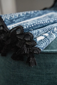 Close-up of blue geometric pattern curtain with detailed black handmade tassels