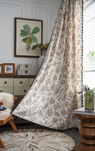 Close-up of vintage floral curtains with rustic brown flower print and black tassel fringe