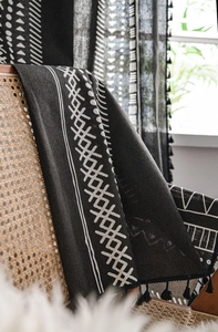 Dettaglio della tenda in cotone con motivo tribale geometrico e eleganti frange nere