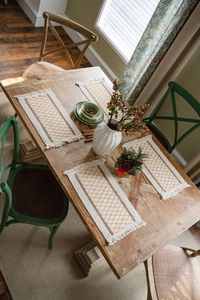 Close-up of bohemian woven placemats with geometric diamond patterns and tassel edges