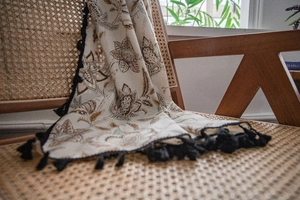 Detail view of American rural style floral print curtain with elegant black fringe edges