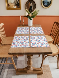 Close-up of four rectangle cotton linen placemats with vintage floral prints on a wooden table