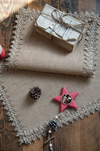 Detail showing natural jute table runner with lace edge on a rustic wooden surface