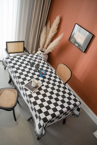 Detailaufnahme der schwarz-weiß karierten Tischdecke mit Textur und eleganten Quasten