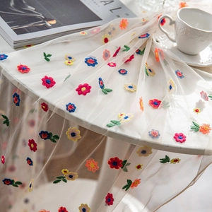 White lace tablecloth with colorful floral embroidery for photography backdrop use