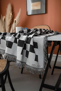 Detailansicht der schwarz-weißen Tischdecke mit Karomuster, Baumwolltextur und Fransen
