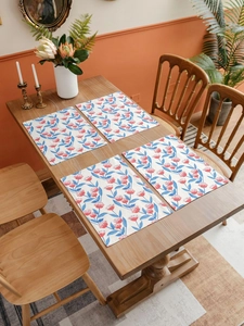 Close-up of linen table mats featuring pink floral prints on a rustic wooden dining table