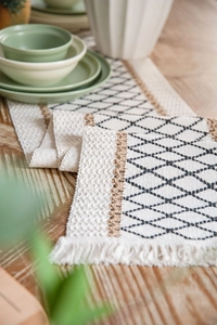 Dettaglio del runner da tavolo boho con motivi a rombi e rifiniture con nappe
