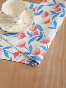 Detailed close-up showing pink floral patterns and stitching on a linen table mat