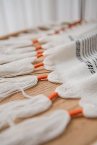 Detailed view of woven chevron tablecloth featuring orange knotted fringe accents