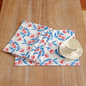Detailed texture of cotton linen placemat with vintage floral print on a wooden table