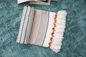 Detailed view of woven nordic tablecloth featuring orange zigzag stripes and handmade tassels