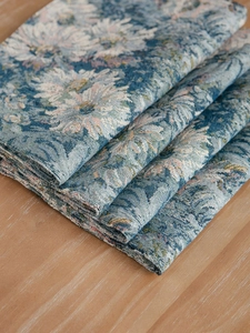 Close-up of blue floral jacquard fabric placemat showing thick woven texture and detail