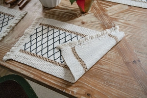 Dettaglio del runner da tavola in cotone e lino intrecciato con nappe e rombi