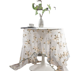 Elegant white lace tablecloth featuring yellow flower embroidery and green wavy edges