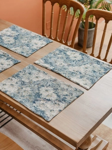 Detailed close-up of blue and white floral jacquard placemats with premium texture