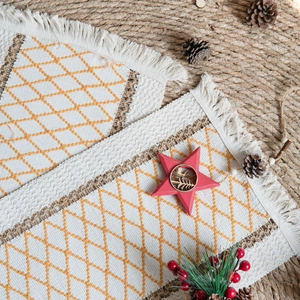 Bohemian woven placemat with orange diamond embroidery and festive tassel edges
