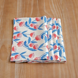 Set of four cotton linen placemats with pink flower print on wooden background
