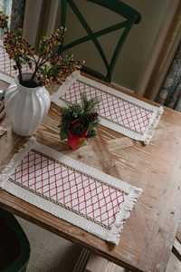 Close-up of cotton linen table runner with red diamond embroidery and soft tassels