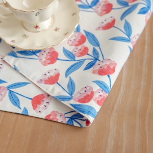 Double-layered floral cotton linen placemat with pink flowers on a wooden table