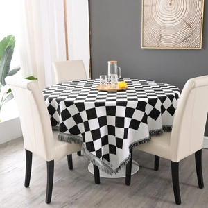 Moderne schwarz-weiße Tischdecke mit Karomuster und grauen Fransen auf Rundtisch