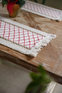 Close-up of cotton linen table runner with red diamond embroidery and elegant tassels