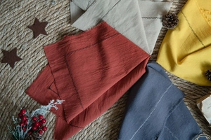 Fringed cotton placemats with zigzag stitching detail on rustic woven mat