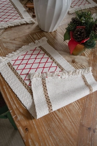 Detailed macro view of woven cotton linen table mat with red rhombus embroidery and tassels