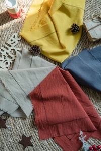 Macro shot of cotton napkins with fringed edges and decorative black stitching detail