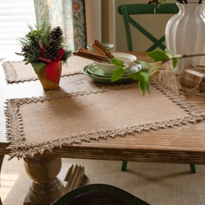 Natural jute table runner with floral lace trim on rustic wooden surface