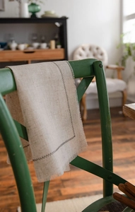 Close-up of beige washed cotton placemat with black zigzag stitching and frayed edges