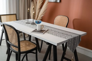 Vue détaillée d'un chemin de table en jacquard géométrique avec motifs noirs et franges