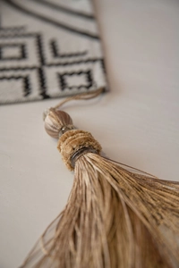 Gros plan d'un gland doré élégant sur un tissu jacquard à motifs géométriques