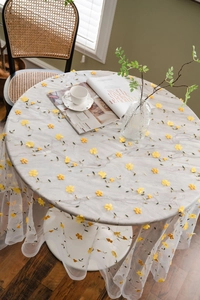 Detailed view of floral embroidery on white sheer tulle tablecloth for photography