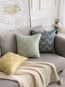 Macro view of modern wave jacquard texture and geometric herringbone pattern on sofa cushions
