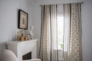 Detail of bohemian cotton linen curtain with black geometric prints and tassel fringe