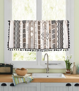 Détail du motif géométrique tribal et des glands à pompons noirs sur le rideau court