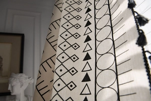 Detail of bohemian cotton linen curtain with black geometric patterns and fringe