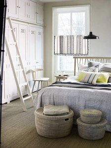 Détail de rideau à motifs géométriques et pompons noirs dans une chambre lumineuse