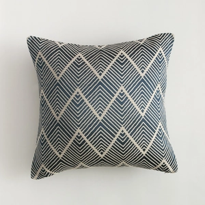 Detail of navy blue and cream geometric chevron jacquard pattern on a square pillow cover