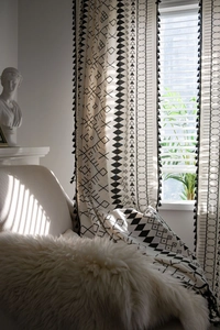 Detail of bohemian cotton linen curtain with black geometric patterns and fringe