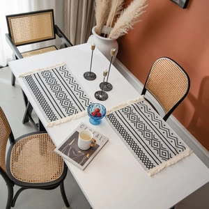 Chemin de table bohème avec motifs géométriques en jacquard et pompons pour décoration