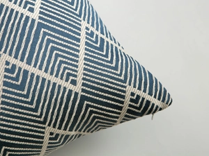 Close-up of geometric blue and white weave texture with hidden zipper detail on pillow cover