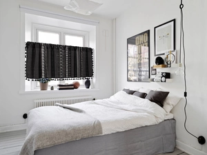 Detail of bohemian geometric half curtain with decorative black pompom fringe trim