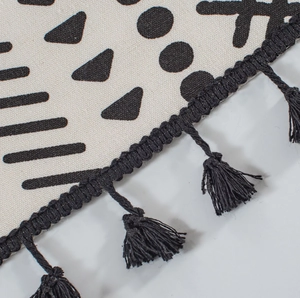 Détail du tissu à imprimé géométrique avec glands noirs faits main et texture en lin