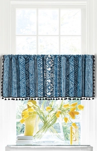 Detail of blue geometric boho window curtain with elegant black tassels and floral decor