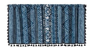 Detailed close-up of blue geometric tribal pattern fabric with black fringe tassels