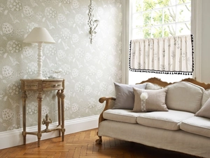 Detail of floral sketch print on cafe curtain with black tassel trim on beige fabric