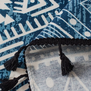 Detail of blue geometric printed curtain fabric with handmade black woven tassels